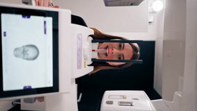 vertical video portrait of a beautiful woman doing a 3D scan of the nose and oral cavity in plastic surgery clinic