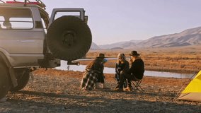 Group of Friends reparing coffee near travel suv. People enjoying a day camping. Autumn vacations and relationship concept. Picnic near car on sunset outside. Domestic travel concept. - Powered by Shutterstock - Get 15% off with code: PIKWIZARD15