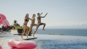 Pool party friend together have fun with splash laughter enjoy happy memories of sunny day slow motion. Friends jump in ocean view infinity pool at luxury hotel resort villa celebrate summer vacation - Powered by Shutterstock - Get 15% off with code: PIKWIZARD15