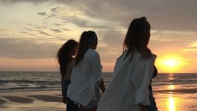 back view of three women in summer clothes walking on the beach at sunset - Powered by Shutterstock - Get 15% off with code: PIKWIZARD15