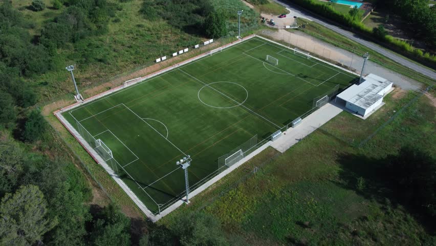 Soccer field at roadside in Gualba. Recreational area, aerial drone 4k