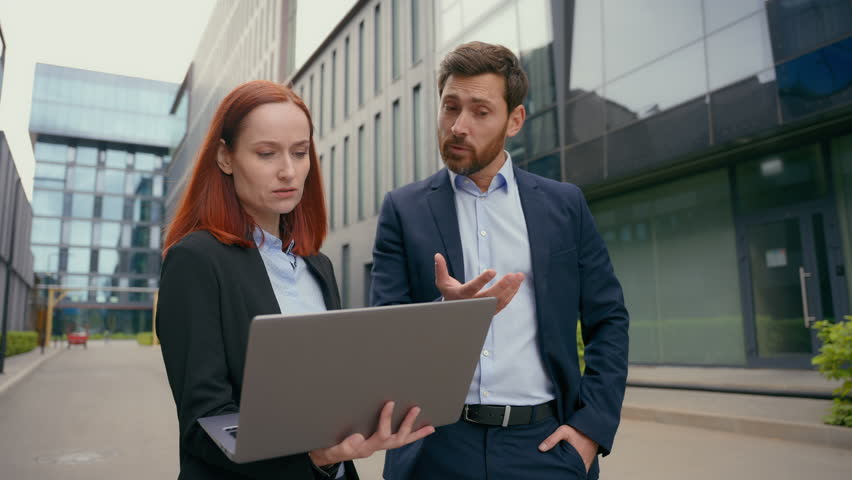 Caucasian business man boss reprimanding female employee worker woman showing online mistake bad work result company leader dissatisfied with laptop data talking scolding computer failure in city Royalty-Free Stock Footage #3400504731