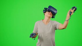 The woman wearing VR headset dancing in virtual reality. The girl on chroma key green screen background in virtual reality dancing in game.Concept dance in VR headset leisure activity virtual reality