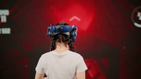 The child use tracking controllers in her hands, moves actively immersing herself in modern game. The little girl wearing VR headset plays game. Behind girl there is screen with blur background image - Powered by Shutterstock - Get 15% off with code: PIKWIZARD15
