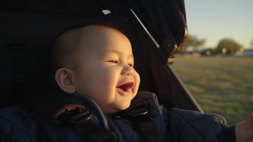 Asian baby laughing in stroller. Slow motion Royalty-Free Stock Footage #3400518731