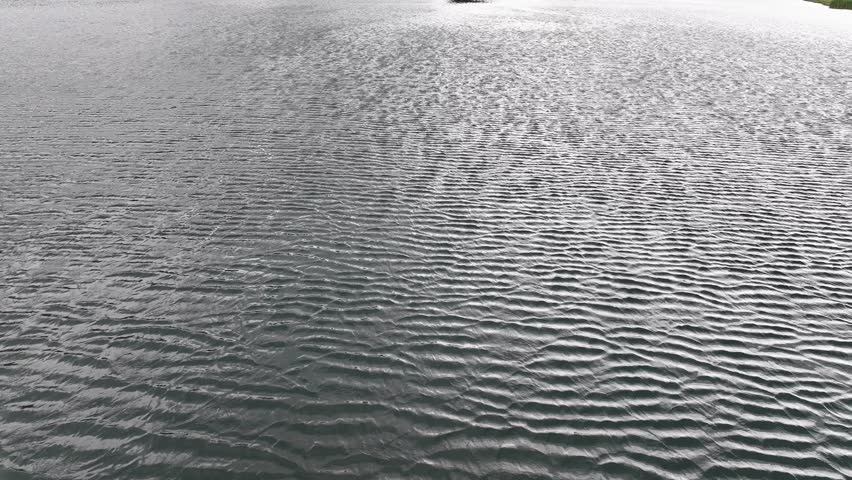 reveal from an alpine lake over the water to a mountain retreat next to a large river in the mountains of Silverthorne colorado on a hazy day AERIAL DOLLY RAISE TILT