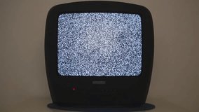 Vintage TV on a nightstand in an empty room. Retro TV with black plastic case in an empty room. Retro old TV standing on a dark background 