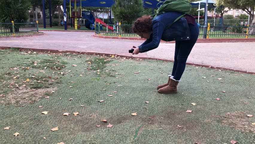 Woman taking a snapshot photograph using hand held point and shoot compact camera | 4k UHD