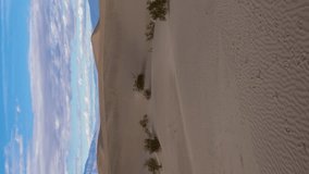 Mesquite Flat Sand Dunes on Sunny Day. Death Valley National Park. California, USA. Moving Time Lapse, Tilt Up. Vertical Video