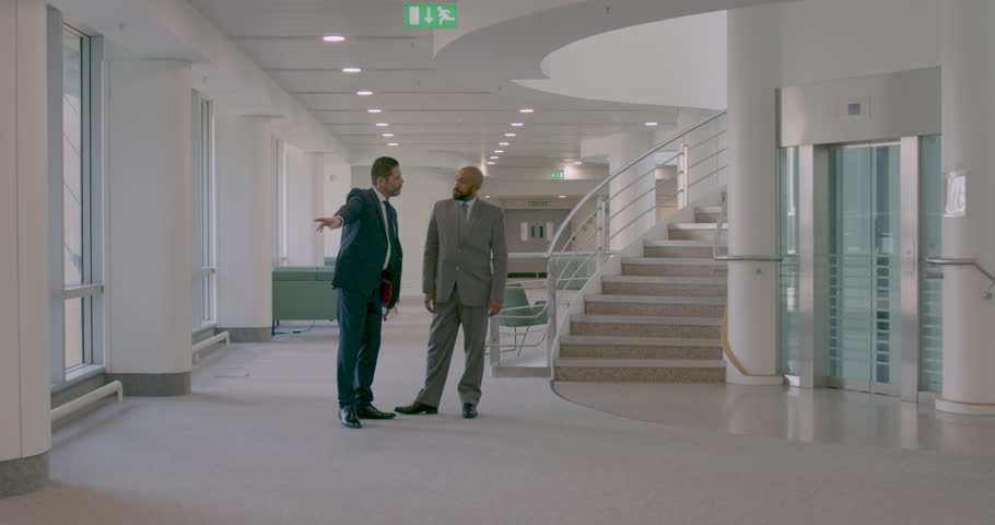 Two Business People Meeting in Corporate Office Lobby
