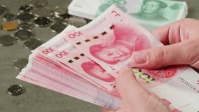 Detailed close up of 100 Yuan, the Chinese currency,CNY. A big wad of money 100 Renminbi the highest denomination of china's money. Footage of chinese banknotes. Counting money, finance - Powered by Shutterstock - Get 15% off with code: PIKWIZARD15
