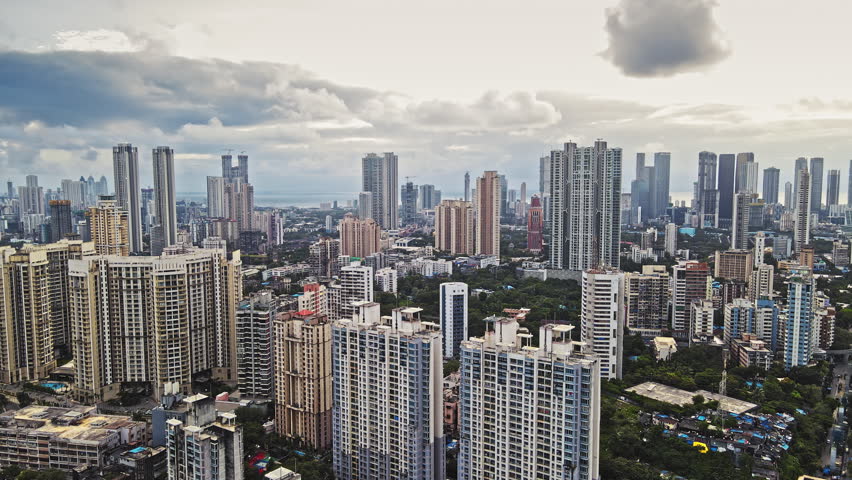 A beautiful aerial view of the high-rise skyscrapers of Mumbai city in Maharashtra during monsoon season under a cloudy skyline.