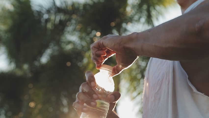 Fitness, man and drinking water for hydration or break after running exercise, workout or training in nature. Male runner with refreshing drink in recovery from cardio exercising or hiking outdoors