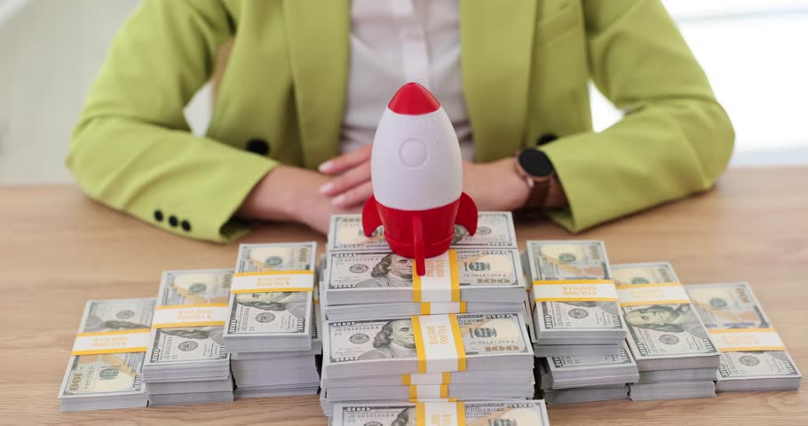 Businesswoman holding rocket and paper dollars. Concept of American currency growth and money investment