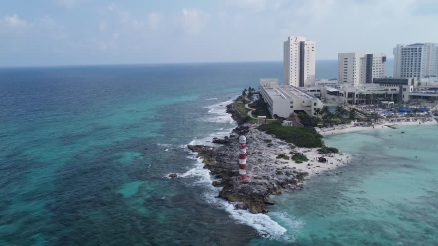 Aerial of the Punta Cancun Lighthouse, a distinguished landmark in Cancun, Mexico, with panoramic views of the peninsula surrounded by turquoise waters.