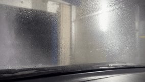 Sliding foam from the windshield. View of an automatic car windshield wash with foam from the car cabin. Automatic car wash view from the car cabin. View from inside. - Powered by Shutterstock - Get 15% off with code: PIKWIZARD15