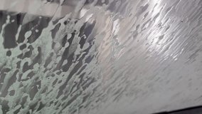 Macro shot of the water pressure washing the foam from the windshield. Automatic car wash view from the car cabin. - Powered by Shutterstock - Get 15% off with code: PIKWIZARD15