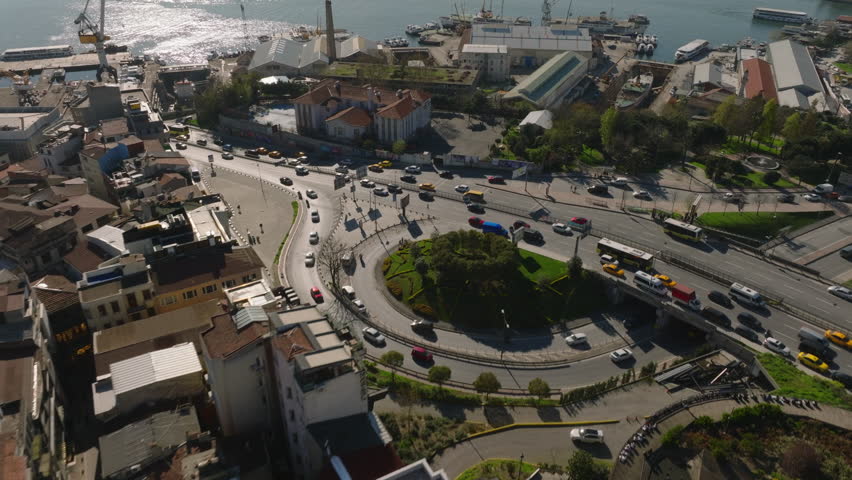 High angle view of heavy traffic on multilane thoroughfare in city. Tilt up reveal water area and metropolis panorama against sunshine. Istanbul, Turkey