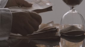 closeup female hands count 50 euro banknotes of european union against background of scattered paper banknotes on table, hourglass, concept Time is money, money laundering, financial scam - Powered by Shutterstock - Get 15% off with code: PIKWIZARD15