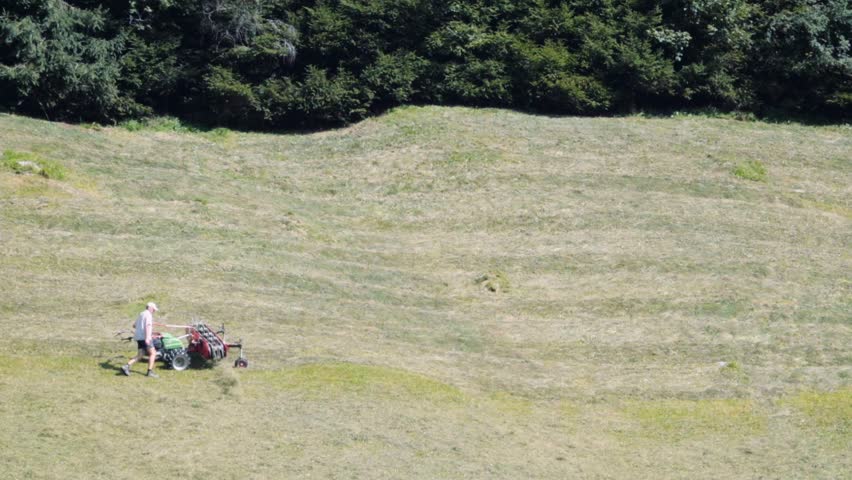 Lawn-mover man working in field.