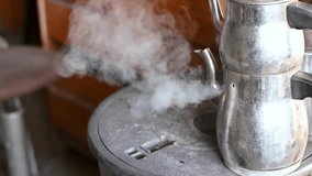 Water vapor coming out of a tea kettle. Mechanic shop stove.