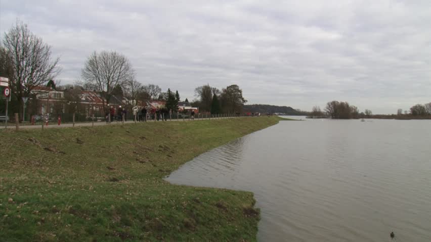 people walking over dike pan inundated floodplains of river Rhine (Lower Rhine) at Wageningen, january 2011