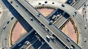 Experience the mesmerizing beauty of the timelapse of interchange roundabout with tunnel from a bird's-eye view. A breathtaking spectacle of urban engineering captured by a drone. Time lapse. 4K HDR.
