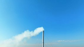 An industrial plant billows thick white smoke into the once-blue sky, symbolizing environmental pollution and posing a grave threat to respiratory health. Carbon footprint and climate change concept. 