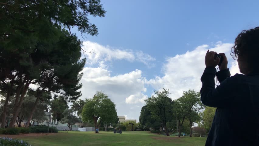 Woman taking a snapshot photograph using hand held point and shoot compact camera | 4k UHD