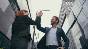 Happy business partners successful businesspeople Caucasian coworkers friends businessman and businesswoman in city near office building celebrate success partnership give high five teamwork talking - Powered by Shutterstock - Get 15% off with code: PIKWIZARD15