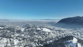 Aerial view of the city of Brasov, covered in snow. Winter in Romanian Mountains. Perfect time for holiday 
