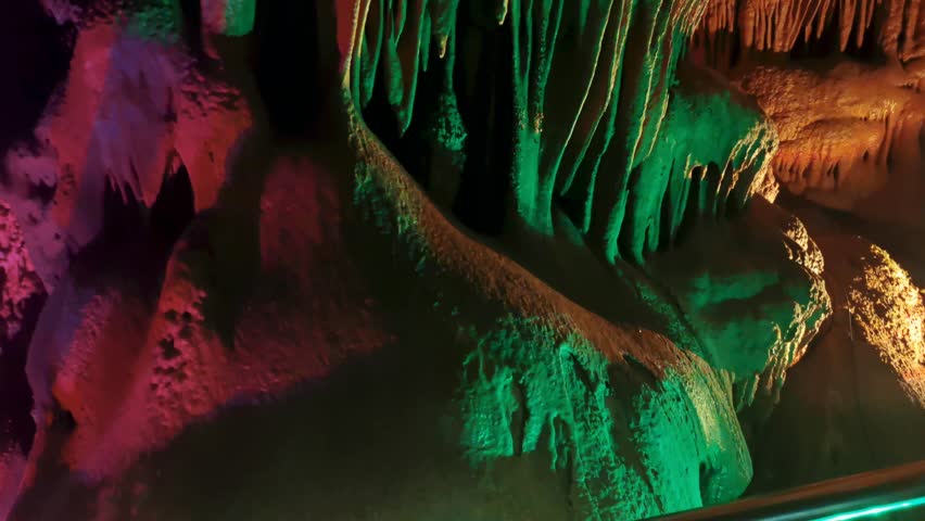 Venetsa Cave near Vidin, Bulgaria. Beautiful colorful and illuminated cave full with semiprecious onyx stones. Flowstones, stalactites and stalagmites lighted in different vivid colours. Royalty-Free Stock Footage #3401407319