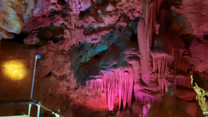 Venetsa Cave near Vidin, Bulgaria. Beautiful colorful and illuminated cave full with semiprecious onyx stones. Flowstones, stalactites and stalagmites lighted in different vivid colours. Royalty-Free Stock Footage #3401407425