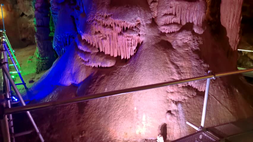 Venetsa Cave near Vidin, Bulgaria. Beautiful colorful and illuminated cave full with semiprecious onyx stones. Flowstones, stalactites and stalagmites lighted in different vivid colours. Royalty-Free Stock Footage #3401407567