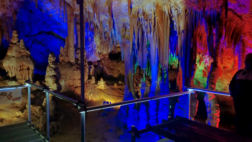 Venetsa Cave near Vidin, Bulgaria. Beautiful colorful and illuminated cave full with semiprecious onyx stones. Flowstones, stalactites and stalagmites lighted in different vivid colours. Royalty-Free Stock Footage #3401407727