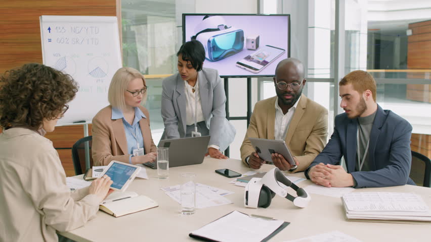Group of several co-workers sitting in well-lit conference room of their corporation brainstorming new ideas Royalty-Free Stock Footage #3401434099