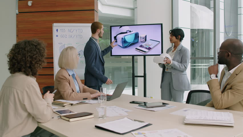 Marketing team with two project leaders standing in well-lit meeting room brainstorming ideas of better promotion of new VR set Royalty-Free Stock Footage #3401447969