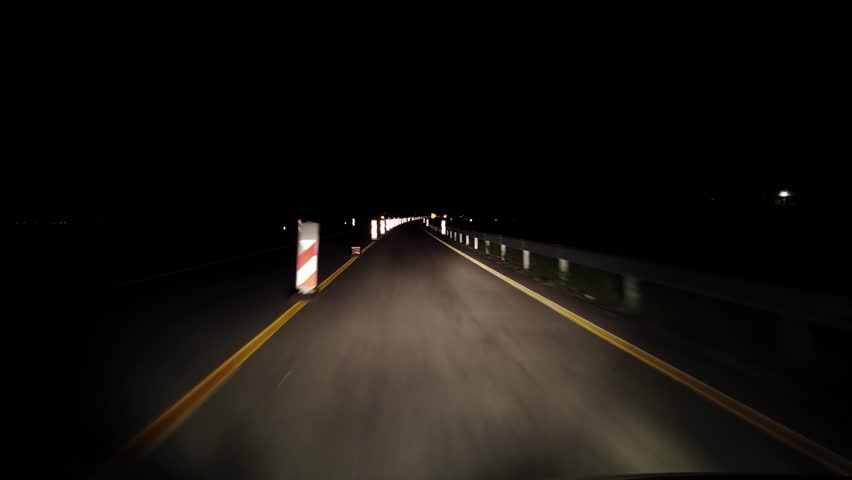 Pov driving at night on highway with restricted line and warning dirrection roadwoaks hinder pylon signs