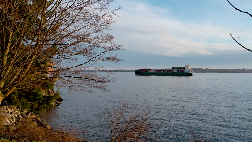 Vancouver, British Columbia, Canada. Aerial drone tracking video of assistive tug boat cruising in Vancouver harbor, one of the biggest and most important logistics port on the American West Coast.