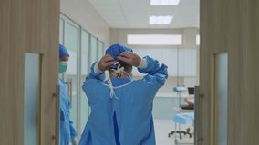 Professional doctors tying a surgical cap while walk into operating room. Attractive specialist medic surgeon medical team and assistant working and preparing performing surgical operation in hospital - Powered by Shutterstock - Get 15% off with code: PIKWIZARD15