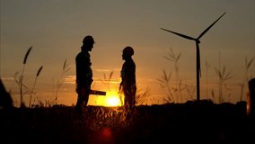 Silhouette of engineer and worker shaking hands on wind turbine background - Powered by Shutterstock - Get 15% off with code: PIKWIZARD15