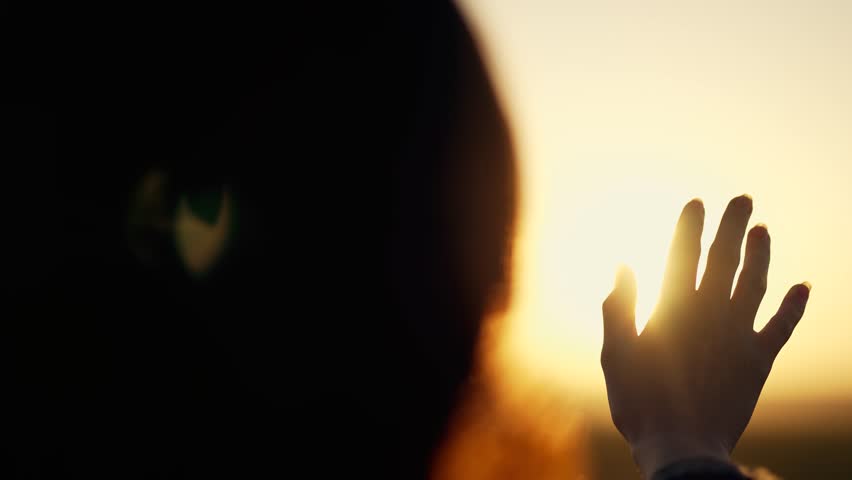 Hand of happy girl at sunset. Sunset between the hands of girl. Happy girl with long hair dreamily stretches out her hand to sun. Child's dream hand to the sun. happy family concept. Freedom in nature Royalty-Free Stock Footage #3401751081
