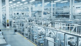 Aerial Footage with Electronics Factory 3D Concept. Automated Robotic Arm Assembly Line Manufacturing Advanced High-Tech Components. Industrial Production Conveyor Line Monitored by AI Mobility Robots - Powered by Shutterstock - Get 15% off with code: PIKWIZARD15