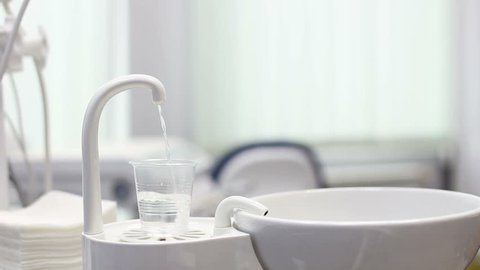 Dentist's water rinse cup tap pip filler in dental clinic