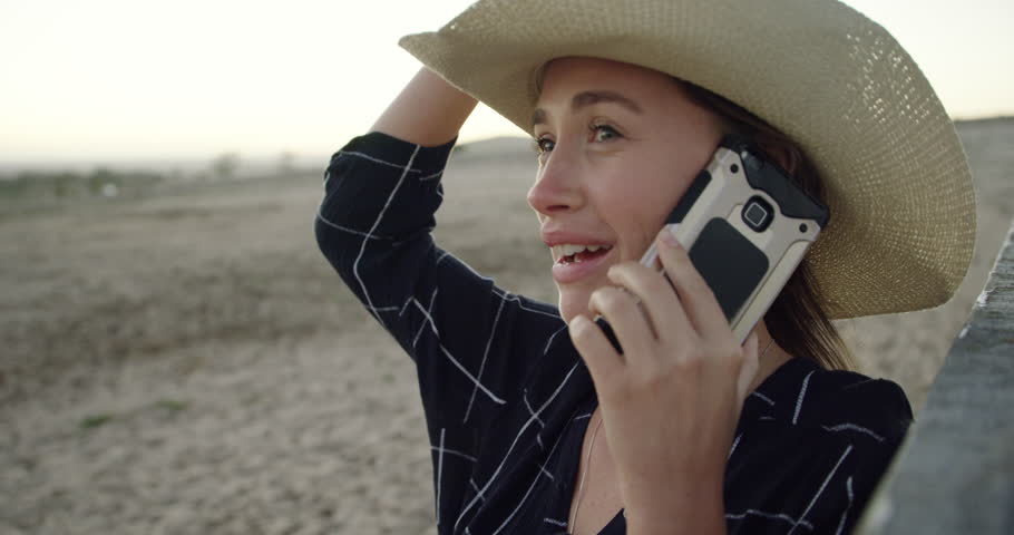 Woman, ranch or farm with phone call, talk or thinking with chat, agriculture and communication. Cowgirl, farmer or person with smartphone, conversation and happy on field for sustainability in Texas