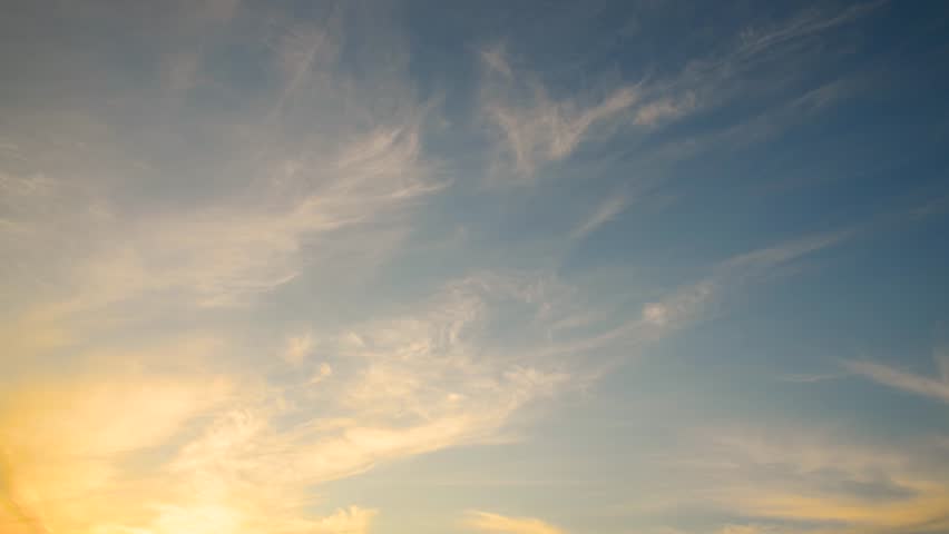 Clouds move across the blue sky at sunset. Beautiful evening cloudy landscape. Copy space. It's getting dark. Time lapse video 4K.