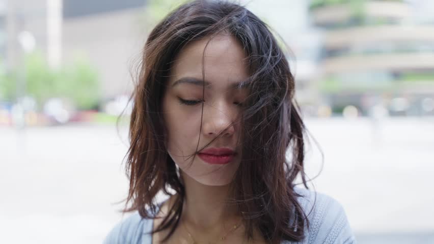 portrait of Charming young asian woman smile at camera in the urban city square