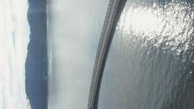 Car is Going on Storseisundet Bridge. Atlantic Ocean Road in Norway. Aerial View. Drone Orbits Around, Camera Tilts Down. Vertical Video