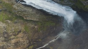 Voringfossen Waterfall and Cliff in Norway at Autumn Day. Aerial Vertical Top-Down View. Drone Flies Forward and Upwards, Camera Tilts Down. Vertical Video