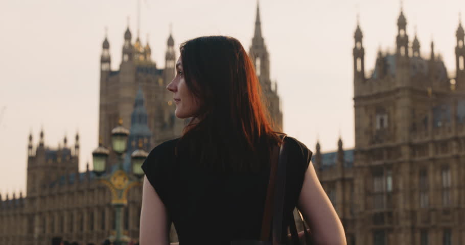 Beautiful Caucasian female tourist looking around, standing in front of House of Lords in London